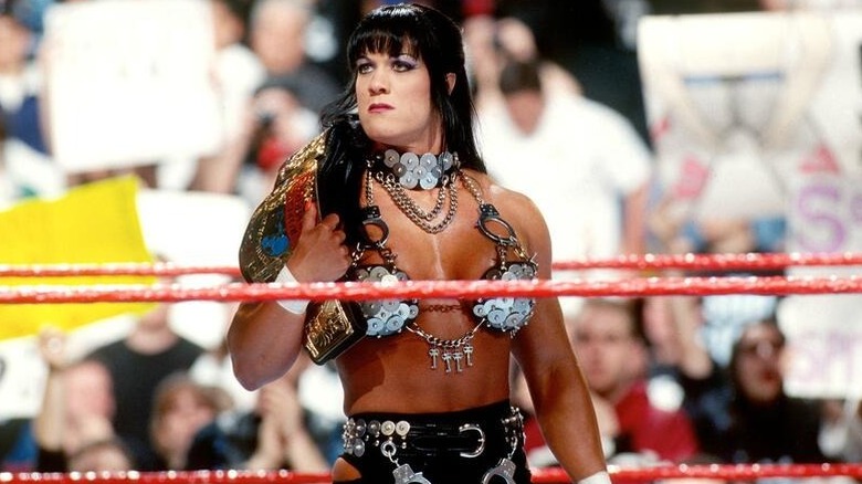 Chyna poses in the ring, holding the Intercontinental Championship, during an episode of WWE programming.