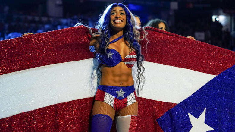Zelina Vega smiles widely as she poses with her Puerto Rican-inspired gear.